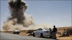 Smoke rises following an air strike by Libyan warplanes near a checkpoint near the anti-Libyan Leader Moammar Gaddafi rebels checkpoint in the oil town of Ras Lanuf, eastern Libya, 7 March 2011